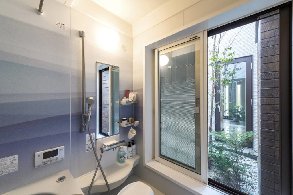 写真：大きな窓から中庭の緑を楽しめる浴室